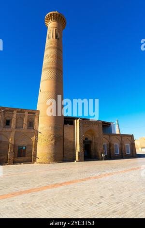 Minarett der antiken Moschee vor dem Polvon-Darvoza-Tor zur Altstadt (Ichan Kala) in Chiwa, Usbekistan. Zur Altstadt von Ichan Kala und der antiken Moschee KH Stockfoto