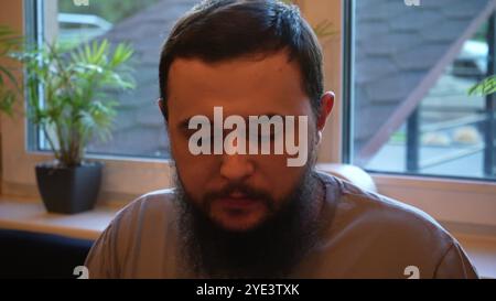 Ein dunkelhaariger junger Mann wartet in einem Restaurant auf einen Auftrag. Halb-romantisch und sehr angenehme Atmosphäre. Stockfoto