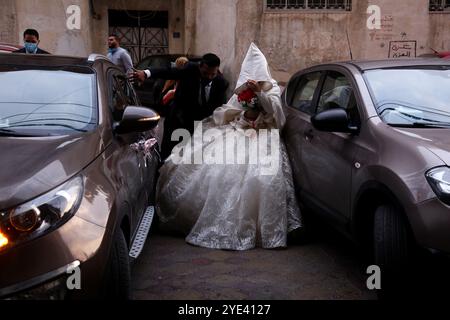 Gaza-Stadt, Palästina. September 2020. Ein palästinensisches Paar heiratet in Gaza-Stadt in einer kleinen Hochzeitszeremonie, die auf ihre engsten Familienmitglieder beschränkt ist, wobei soziale Distanzierung und Gesichtsmasken Teil der Veranstaltung sind. Seit dem 24. August, als erstmals COVID-19-Fälle bei der Bevölkerung des Gazastreifens festgestellt wurden, ist die Zahl der Virusinfektionen im palästinensischen Gebiet drastisch gestiegen. Die Behörden haben mit der steigenden Zahl von Fällen im Gazastreifen zu kämpfen, einem der bevölkerungsreichsten Gebiete der Welt und einer überlasteten und zu geringen Gesundheitsinfrastruktur Stockfoto