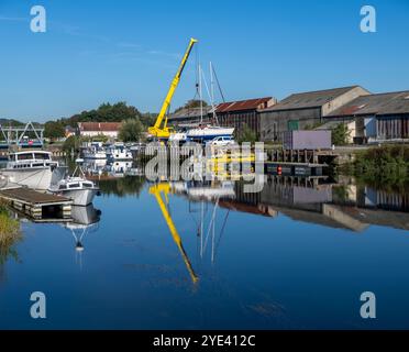 Ein Kran hebt ein Boot aus, um es für seine Winterschlafzeit in Saint Valery sur Somme, Nordfrankreich, vorzubereiten. Stockfoto