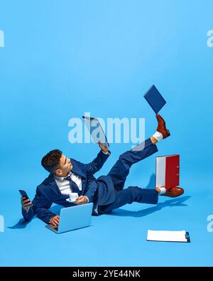 Kreative Collage. Geschäftsmann mit mehreren Händen auf dem Boden, Jonglierbecher, Laptop und Telefon. Moderner Workflow, dynamische Geschäftsumgebungen. Stockfoto