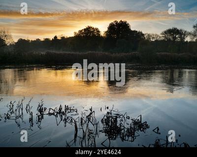 Sonnenaufgang über einem wunderschönen Abschnitt der Themse am Radley Boathouse. Das 1921 gegründete Bootshaus dient seit über einem Jahrhundert Radley College und einheimischen Ruderfreunden. Die Aussicht von hier kann besonders schön sein bei Sonnenaufgang - wie hier. Stockfoto