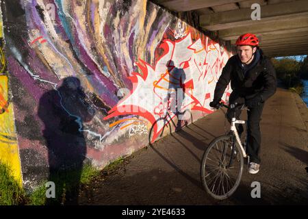 Graffiti und Schatten unter der Donnington Brücke über die Themse. Es ist früh an einem Herbstmorgen und ich bin auf meinem täglichen Spaziergang. Ich bin unter der Donnington Brücke über die Themse, direkt unterhalb von Oxford. Dies ist eine moderne Straßenbrücke, die die B4495 von der Abingdon Road zur Iffley Road führt. Er überquert den Fluss an der Grenze zwischen Iffley Lock und Osney Lock. Dies ist Teil des Thames Path Walkway, einer Strecke, die häufig von Radfahrern, Joggern und Hundebesitzern besucht wird - ganz zu schweigen von Fotografen! Stockfoto