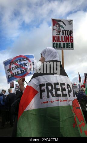 Shenstone, England, Großbritannien. Oktober 2024. Während der Demonstration hält ein Demonstrant Schilder mit der Aufschrift „Israel ermordet Kinder“ und „hört auf Kinder zu töten“ außerhalb der UAV-Motoren. Pro-palästinensische Demonstranten halten Druck auf die israelische Rüstungsfirma Elbit Systems in ihrer UAV-Triebwerksanlage in Shenstone. Sie fordern weiterhin, dass das Unternehmen keine Teile für Drohnen mehr produziert, die gegen das palästinensische Volk in Gaza, die Libanesen und die Bevölkerung im Nahen Osten eingesetzt werden. (Kreditbild: © Martin Pope/ZUMA Press Wire) NUR REDAKTIONELLE VERWENDUNG! Nicht für kommerzielle ZWECKE! Stockfoto