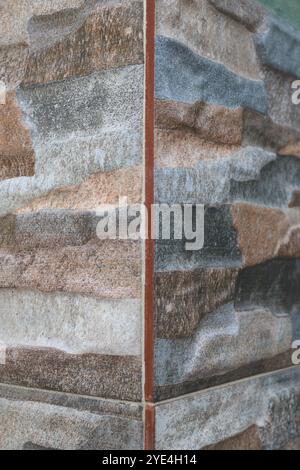 Nahaufnahme mehrfarbiger Steinfliesen mit unterschiedlichen Texturen. Die Erdtöne reichen von Beige bis Dunkelbraun und sorgen für eine natürliche und rustikale Atmosphäre. Stockfoto