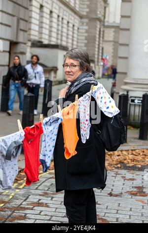 London, Großbritannien. Oktober 2024. Eltern und Kinder von Global Women's Strike und Eltern für Palästina zeigen Hunderte von Baby-Grow-Kleidungsstücken, um die Zahl der Todesopfer von Kindern zu verdeutlichen, die Israel während des Krieges gegen Gaza getötet hat Stockfoto