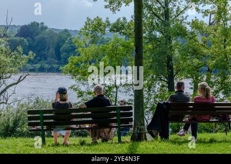 Bonn-Beuel, Deutschland - 21. Mai 2024 : Blick auf zwei Paare, die auf Bänken sitzen und den Blick auf den rhein genießen Stockfoto