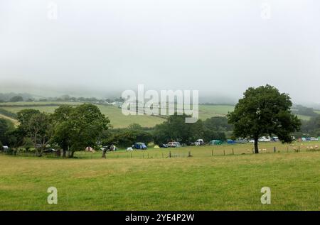 An einem vernebelten Sommertag entspannen Besucher auf dem Steeple Leaze Campsite in Kimmeridge auf der Isle of Purbeck in Dorset. Stockfoto