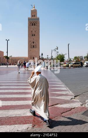 Marrakesch Marokko. Ein Mann überquert die Avenue Mohammed V in der Medina von Marrakesch und geht vom Jemaa El Fna-Platz in Richtung Koutoubia-Moschee Stockfoto