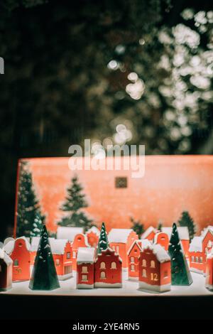 Rote Häuser mit Weihnachtsspielzeug und Schnee auf den Dächern und Weihnachtsbäumen in der Nacht Stockfoto