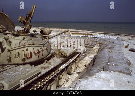 Erster Golfkrieg: 10. März 1991 ein verlassener irakischer chinesischer Panzer Typ 69 in seiner sandsackigen Schutzhülle am Anjafa Beach in Kuwait City. Stockfoto