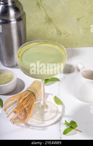 Cremiger Matcha-Martini-Cocktail Matchatini, trendiger kalter Sommercocktail. Matcha alkoholfreier Mocktail oder Alkohol Cocktail, in Martini Gläsern mit GREE Stockfoto