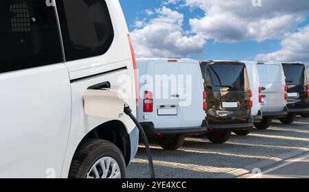 Elektrische Lieferwagen mit Ladestation für Elektrofahrzeuge. Stockfoto