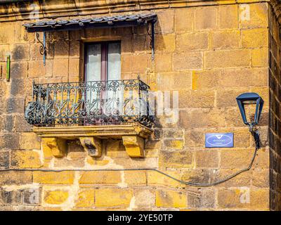 Eine Nahaufnahme eines kunstvoll verzierten, schmiedeeisernen Balkons an einer Steinfassade in der Arraunlari-Straße in Pasajes, Guipuzcoa, Spanien. Stockfoto