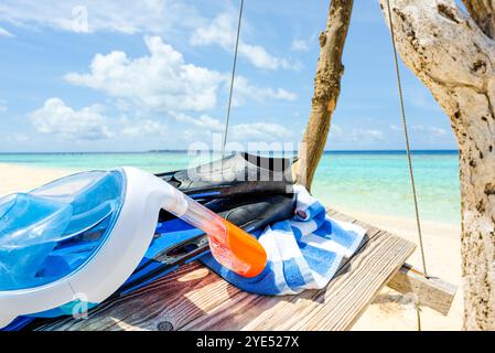 Flossen, ein Handtuch und eine Unterwassermaske auf der Schaukel am Ufer des Indischen Ozeans. Malediven-Inseln. Stockfoto