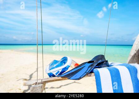 Flossen, ein Handtuch und eine Unterwassermaske auf der Schaukel am Ufer des Indischen Ozeans. Malediven-Inseln. Stockfoto