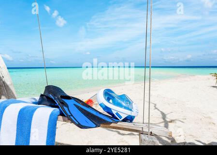 Flossen, ein Handtuch und eine Unterwassermaske auf der Schaukel am Ufer des Indischen Ozeans. Malediven-Inseln. Stockfoto