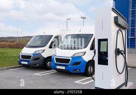 Elektrische Lieferwagen mit Ladestation für Elektrofahrzeuge. Stockfoto