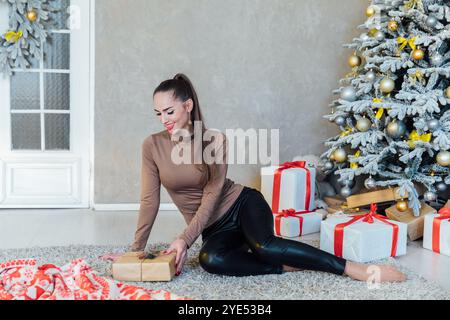 Schöne Frau am weihnachtsbaum mit Geschenken für Neujahr Stockfoto
