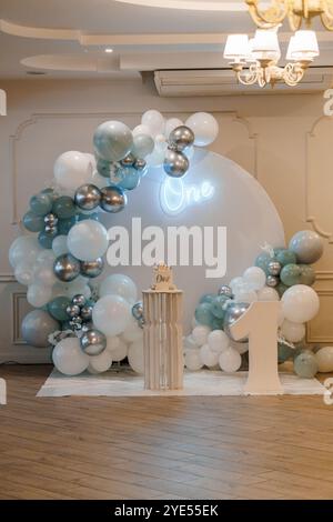 Elegante Feier zum ersten Geburtstag mit Ballonbogen und Kuchenanzeige. Stockfoto