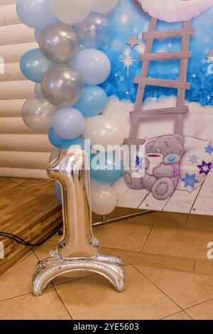 Silberfolie Ballon Nummer eins umgeben von blauen und weißen Ballons für den ersten Geburtstag. Stockfoto