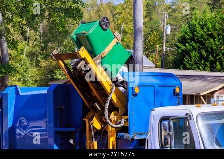 Ein Mitarbeiter des kommunalen Reinigungsdienstes lädt gemischten Hausmüll zur Entsorgung auf den Müllwagen Stockfoto