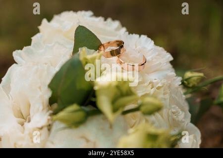Romantische Hochzeitsringe auf eleganten weißen Blumen. Stockfoto