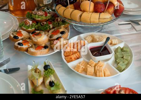Eleganter Tisch mit verschiedenen Vorspeisen, Obst und Käse. Stockfoto
