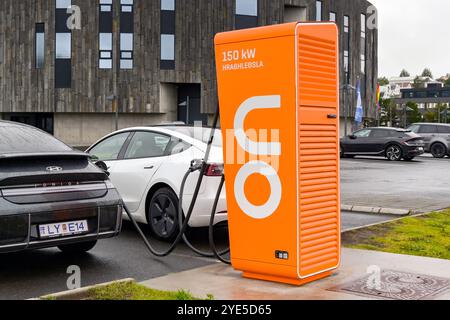 Akureyri, Island - 24. August 2024: Elektroautos werden an eine Schnellladestation in der Nähe des Stadtzentrums angeschlossen Stockfoto