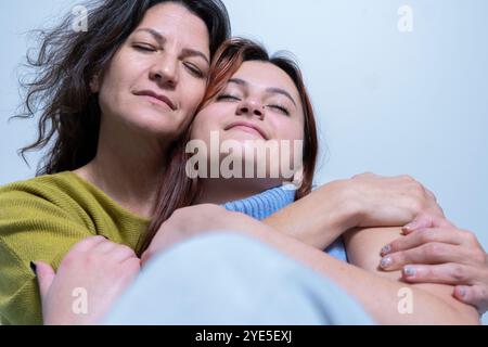 Ein berührender Moment zwischen einer Mutter und ihrer Tochter auf einem schlichten Hintergrund Stockfoto