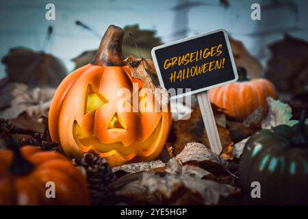 FOTOMONTAGE, Halloween-Kürbis mit Herbstlaub und Schild mit Aufschrift Gruseliges Halloween *** FOTOMONTAGE, Halloween Kürbis mit Herbstlaub und Schild mit der Aufschrift Gruseliges Halloween Stockfoto