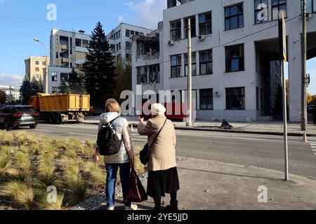 CHARKIW, UKRAINE - 28. OKTOBER 2024 - Frauen beobachten die Folgen der russischen Bombardierung des Derschprom-Gebäudes in Charkiw, Nordostukraine Stockfoto
