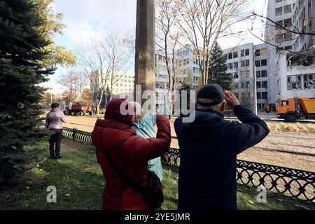 CHARKIW, UKRAINE - 28. OKTOBER 2024 - Menschen beobachten die Folgen der russischen Bombardierung des Derschprom-Gebäudes in Charkiw, Nordostukraine Stockfoto