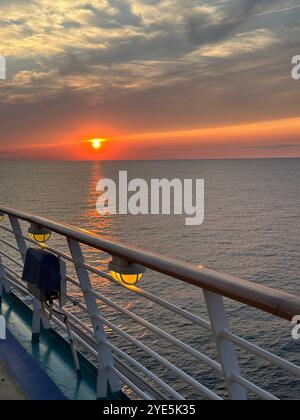 Sonnenuntergang an einem klaren Tag auf einem Kreuzfahrtschiff über dem Meer. Stockfoto