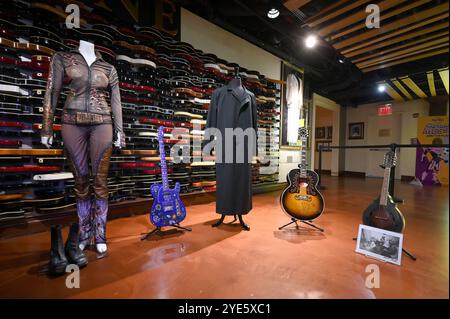 New York, USA. Oktober 2024. (L-R) Britney Spears 2001-2002 auf der Bühne getragene 'Dream Within a Dream'-Tour und Prince auf der Bühne gespielte Gitarre Sadowksy telecaster, Johnny Cash Weed Coat, The Rolling Stones Ronnie Woods signierte 1997 Gibson VS-J 200 signierte Gitarre mit Fotos und das Levon Helm Studio der Band spielte Mandola (mit Fotos) während Juliens 'Played, Weed & Torn' Auktion im Hard Rock Cafe in New York, 28. Oktober 2024. (Foto: Anthony Behar/SIPA USA) Credit: SIPA USA/Alamy Live News Stockfoto