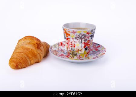 Ein einfaches, aber elegantes Frühstück mit Croissants und Kaffee auf einem hellen Marmortisch. Die Szene unterstreicht eine friedliche Morgenatmosphäre im Detail Stockfoto