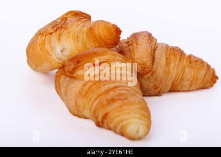 Nahaufnahme von Croissants auf nahtlosem weißem Hintergrund mit Schwerpunkt auf ihrer schuppigen Textur und goldenen Kruste in einer sauberen, einfachen Umgebung Stockfoto