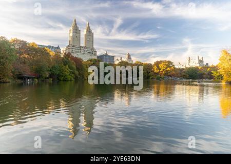 Halten Sie die lebendige Schönheit des Central Park an einem sonnigen Oktobertag fest und bewundern Sie die leuchtenden Farben des Herbstlaubs der Bäume rund um den See. Dieser Ser Stockfoto