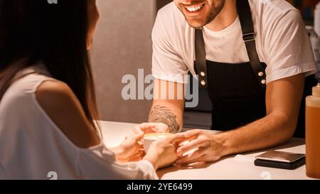 Barista, Der Kaffee Flirtet Und Den Weiblichen Kunden Im Café Aufsteht Stockfoto