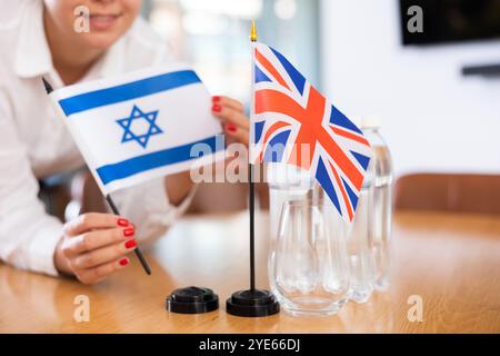 Koordinator des Büros, der die Flaggen Israels und des Vereinigten Königreichs auf den Tisch setzt Stockfoto