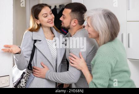 Die Familie begrüßte und umarmte Frau, die nach der Geschäftsreise kam Stockfoto