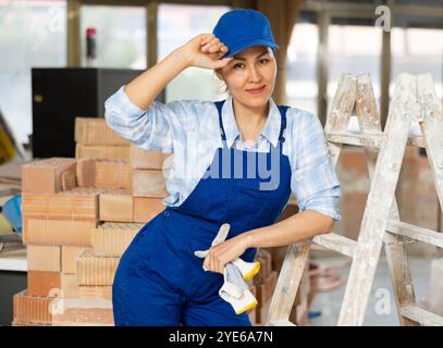 Baumeisterin posiert auf der Baustelle im Innenbereich Stockfoto