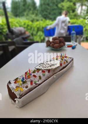 Feste Geburtstagskuchen mit Gummibären auf einem Tisch im Garten, Kindergeburtstag Stockfoto