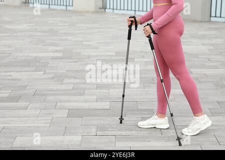 Sportliche Frau, die Nordic Walking auf Böschungen macht Stockfoto