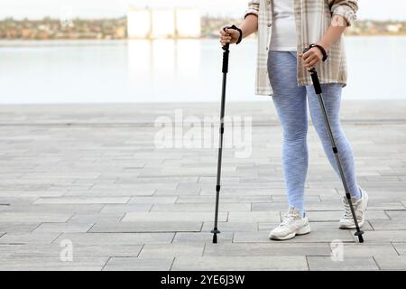 Sportliche Frau, die Nordic Walking auf Böschungen macht Stockfoto