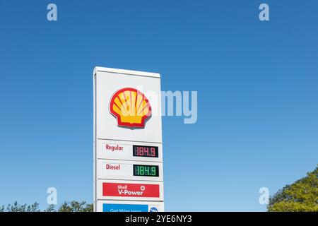 Nahaufnahme des Shell Tankstellenschilds mit den Kraftstoffpreisen für Normal und Diesel, fotografiert an einem sonnigen Tag mit blauem Himmel Hintergrund. Stockfoto