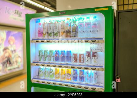 Verkaufsautomat mit einer Auswahl an Getränken einschließlich Wasser, Limonade und Saft. Die Maschine ist grün und mit einer Verriegelung versehen Stockfoto