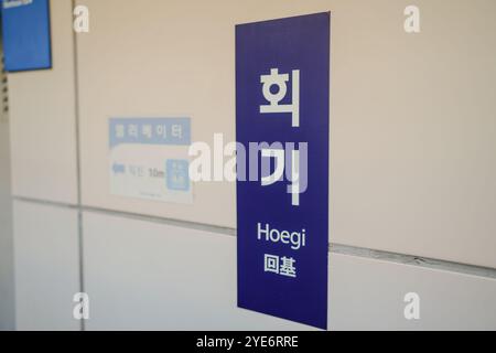 Blaues Schild mit dem Wort "Heogi" auf Chinesisch. Das Schild ist an einer weißen Wand Stockfoto