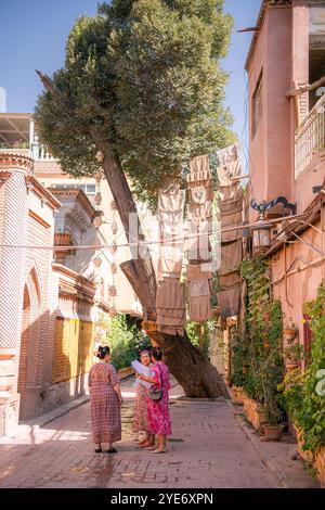 Kashgar, Xinjiang, China - 17. JULI 2023: Uigurische Frauen spazieren durch die Wohngegend der antiken Stadt Kashgar Stockfoto