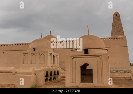 Das Emin-Minarett und die uigurische Moschee, sichtbar hinter den Gräbern in Turpan in der Provinz Xinjiang in Westchina Stockfoto